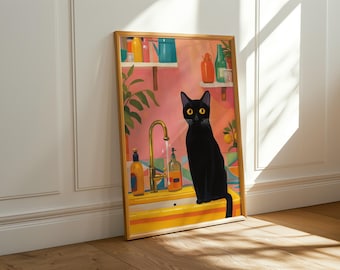 May include: A framed art print featuring a black cat with yellow eyes sitting in a colorful kitchen scene. The artwork includes a gold faucet, bottles, and a pink background. The frame is a warm, natural wood color.