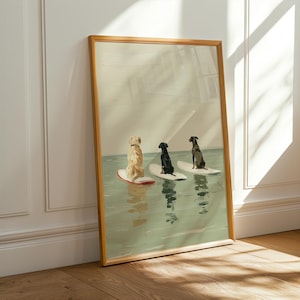 May include: A framed art print featuring three dogs on surfboards in the water. The dogs are a golden retriever, a black dog, and a dark brown dog. The surfboards are white with red accents. The water is a light green color.