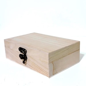 May include: A plain wooden box with a hinged lid and a brass latch. The box is made of light-colored wood and has a smooth finish.