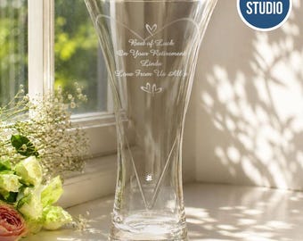 May include: A clear glass vase with a flared rim and a tapered base. The front is etched with a heart outline, two small heart icons, and the text: Best of Luck On Your Retirement Linda Love From Us All. A single clear crystal is set below the text.