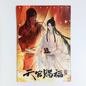 以下が含まれることがあります： 伝統的な衣装を着た2人の人物が、赤と黄色のグラデーションの背景に描かれた本の表紙。表紙には中国語のテキストとイラストが描かれています。この本はグラフィックノベルまたはアートブックのようです。