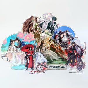 May include: A collection of multi-layered acrylic standees featuring various anime-style characters in traditional and modern attire. The display includes figures with red umbrellas, floral motifs, and Chinese text, all mounted on clear rectangular bases.