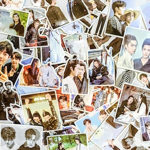 May include: A collection of glossy stickers featuring various Asian actors and characters. The stickers showcase images of people in various outfits and poses, with a variety of colors and styles. The stickers are of different shapes and sizes.