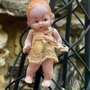 Antique German miniature doll repurposed into a unique necklace