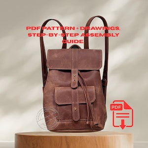 May include: A brown leather backpack with a flap closure and front pocket. The bag has adjustable straps and a drawstring closure. Text on the image reads "PDF PATTERN + DRAWINGS, STEP-BY-STEP ASSEMBLY GUIDE". A PDF icon is also present.