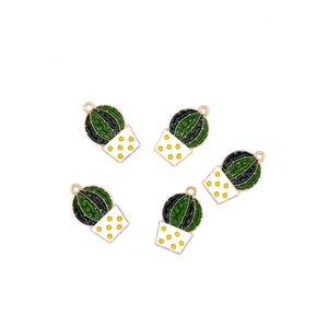 May include: Five gold-coloured cactus charms. Each charm features a green and black cactus in a white pot with yellow polka dots. The charms are set against a white background.