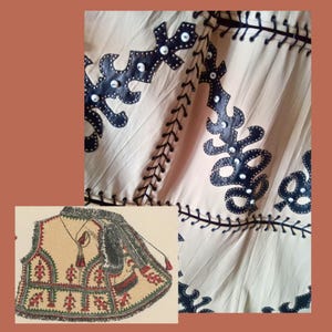 May include: A close-up of a cream-coloured textile with black leather-like appliqu&eacute;s and white accents. The design features decorative shapes and stitching. A vintage illustration of a vest with red and green embroidery is in the lower left corner.