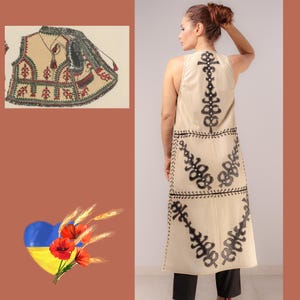 May include: A long, beige sleeveless vest featuring black embroidered floral patterns. The vest, reaching the ankles, has detailed back designs. An illustration of a similar vest is on the left. The image also includes a Ukrainian flag and flowers.