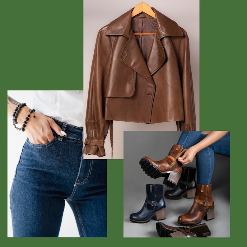 May include: A brown leather jacket with a wide collar and a button closure hangs on a wooden hanger. The image also shows a person wearing blue jeans and a black bracelet, and several pairs of brown and black leather boots.