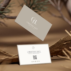 Może przedstawiać: Dwie wizytówki z napisem "CHRISTINA ALICE BEAUTY STUDIO" i logo. Jedna karta unosi się nad drugą, która spoczywa na kawałku drewna. Tło jest neutralne brązowe z gałęziami drzew.