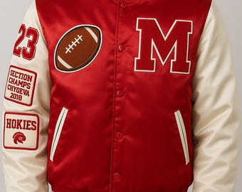 May include: Red satin varsity jacket with cream-colored sleeves. Features a large white "M" patch, a football patch, and patches with the number "23", "SECTION CHAMPS CHYGEVA 2018", and "HOKIES" text. The jacket has a button-up front and striped cuffs.