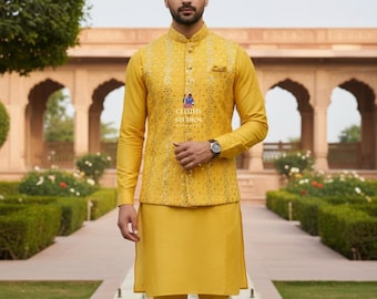 Op de afbeelding: Een gele drieledige outfit met een opstaande kraag. De outfit bestaat uit een shirt met lange mouwen, een vest met een gedetailleerd patroon en een bijpassende broek. Het vest heeft een klein zakje. De outfit wordt gedragen met goudkleurige schoenen. De tekst "CLOTHS STUDIOS" is zichtbaar.