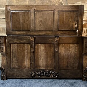 Peut inclure: Un coffre en bois brun foncé avec un couvercle à charnière, des panneaux sculptés et des accents décoratifs. Le coffre a un trou de serrure et des sculptures ornées, dont un motif de grappe de raisin. Le coffre est une solution de stockage.