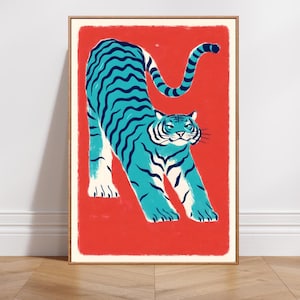 Può includere: Stampa artistica incorniciata con una tigre turchese stilizzata su sfondo rosso. La tigre è raffigurata in posizione di allungamento con strisce nere e dettagli bianchi. L'opera d'arte ha uno stile vintage e illustrativo.