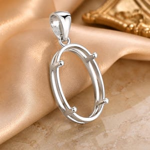 Peut inclure: Un pendentif ovale de couleur argentée doté d'une monture en métal lisse et poli avec quatre griffes conçues pour maintenir une pierre précieuse. Le pendentif comprend une bélière intégrée robuste sur le dessus pour une chaîne.