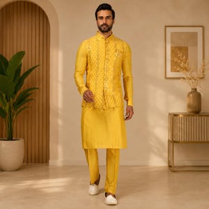 May include: A yellow three-piece suit featuring a long-sleeved shirt, pants, and a vest with a sequined pattern. The outfit is worn with white shoes. The background is a neutral color with a plant in a pot on the left side.