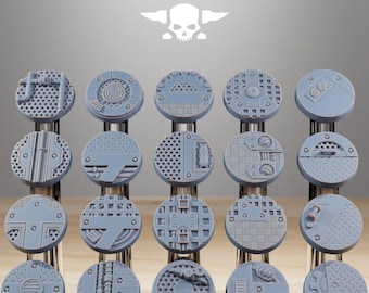 May include: A selection of grey, circular miniature bases with diverse industrial patterns. The bases display textures such as grates, hatches, and mechanical elements. The text "STATIONFORGE" and a skull logo are visible at the top.
