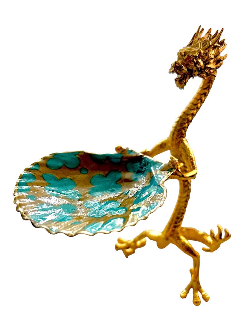 K&ouml;nnte beinhalten: Eine goldfarbene, drachenf&ouml;rmige Dekoschale mit einem t&uuml;rkis-goldenen Becken. Der Drachenkopf ist erhoben, und sein K&ouml;rper bildet die St&uuml;tze der Schale. Die Schale hat einen gewellten Rand.