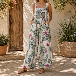 Peut inclure: Une combinaison sans manches à jambes larges avec une base crème ornée d'un imprimé botanique vif composé de feuilles vertes et de fleurs rose vif. Le vêtement présente une encolure dégagée, des bretelles épaisses et deux poches latérales.