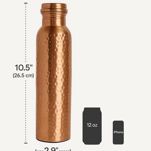 Puede incluir: Una botella de agua de color cobre con una superficie texturizada. La botella mide 26,5 cm de alto y 7,4 cm de ancho. La botella tiene una capacidad de 1 litro. La imagen tambi&eacute;n incluye una lata de 12 oz y un iPhone para comparar tama&ntilde;os.