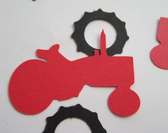 May include: Red and black paper cutouts of tractors and wheels. The tractor cutouts are a simple silhouette of a tractor with a single wheel on the back. The wheels are round with a scalloped edge.