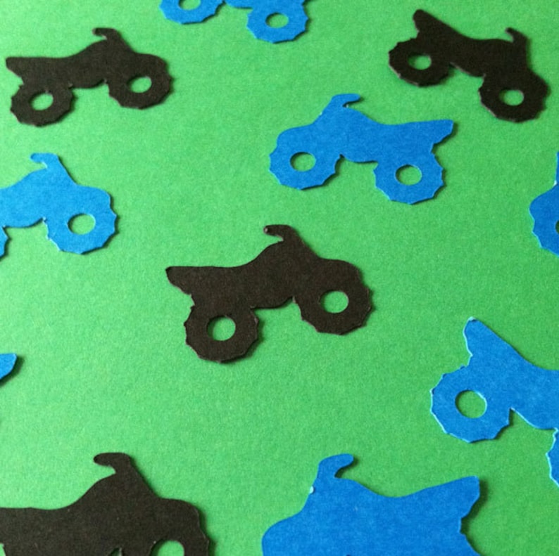 Puede incluir: Una colecci&oacute;n de recortes de papel azul y negro de quads. Los recortes est&aacute;n esparcidos sobre un fondo verde.