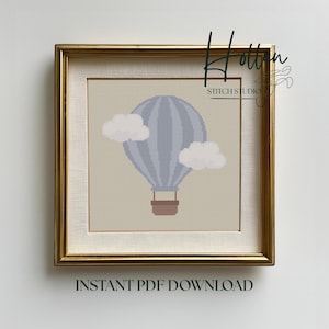 Puede incluir: Un patrón de punto de cruz enmarcado con un globo aerostático azul con dos nubes blancas. El globo tiene una cesta marrón. El marco es dorado. El texto en la parte inferior dice "INSTANT PDF DOWNLOAD".