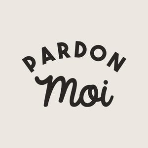 May include: Cream-colored background with the words "PARDON" arched above "Moi" in black. The word "PARDON" is in a bold, sans-serif font, while "Moi" is in a cursive script. The design is simple and elegant.