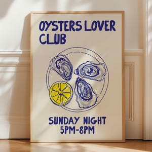 May include: A framed art print with the text "OYSTERS LOVER CLUB" in blue. The print features a plate with three oysters and a lemon slice, also in blue. Below, it reads "SUNDAY NIGHT 5PM-8PM". The artwork has a minimalist, illustrative style.