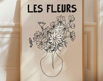 May include: A framed art print featuring a black and white line drawing of a bouquet of flowers in a vase. The words "LES FLEURS" are printed in bold black letters at the top of the print. The artwork is set against a cream-colored background.