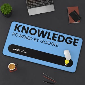 May include: A blue rectangular mousepad with the word "KNOWLEDGE" and "POWERED BY GOOGLE" printed in black. A black search bar with "Search..." is at the bottom. A white mouse and a yellow lightbulb icon are also visible.