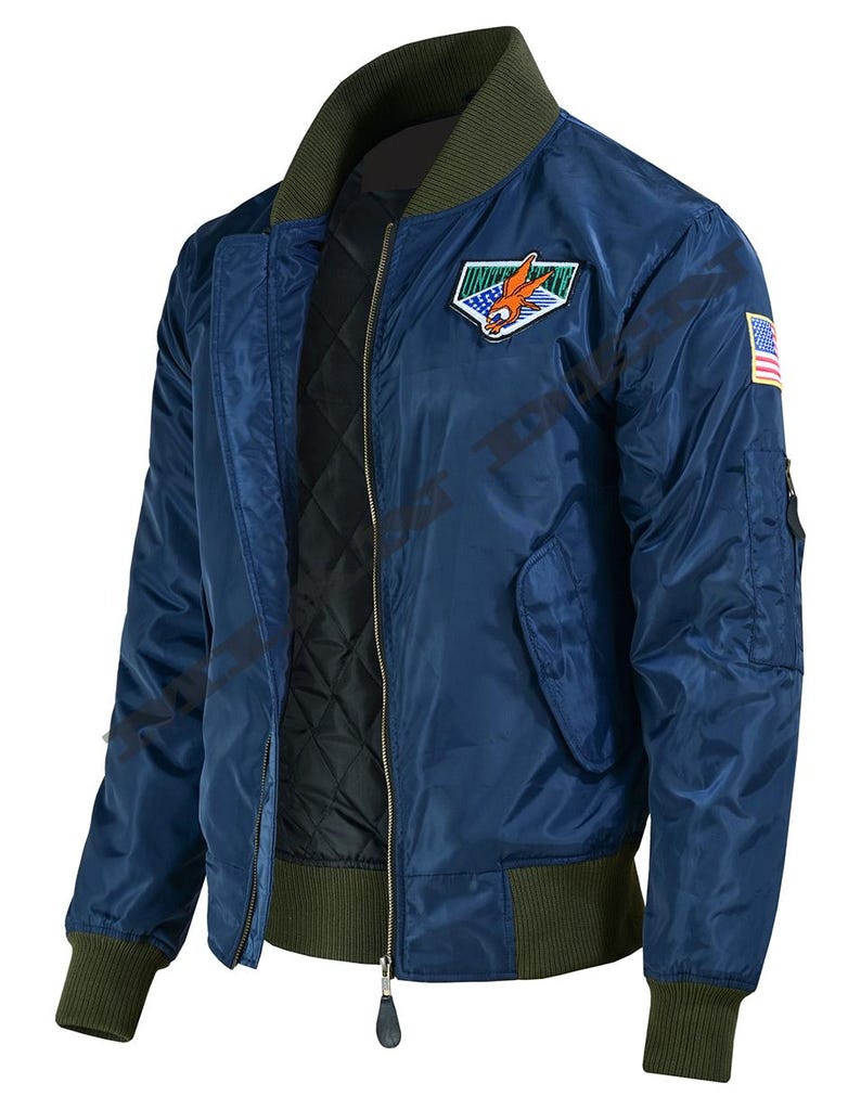 May include: A navy blue bomber jacket with a green collar, cuffs, and waistband. The jacket features a patch with an eagle and a US flag patch on the sleeve. It has a zipper closure and a quilted black lining.