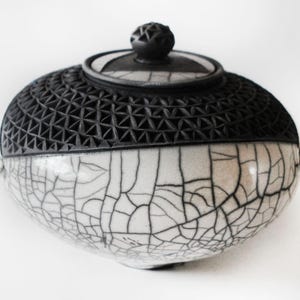 Witte raku-craquelé met pot met onderingedrukt zwart patroon