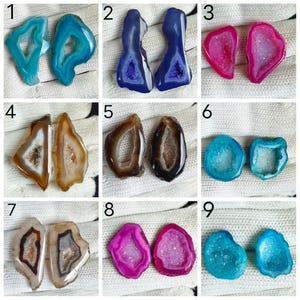 May include: A collection of nine pairs of polished agate geode slices, each featuring a central crystalline cavity surrounded by concentric bands of color including turquoise, deep blue, magenta, brown, black, and light blue, arranged in a grid.