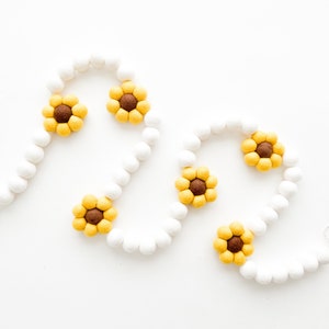 Guirnalda, banderín o pancarta sencilla con grandes bolas de fieltro de girasol.