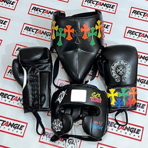 May include: A set of black boxing gear, including gloves, headgear, and a face protector. The gloves and face protector feature colorful cross designs. The headgear has a spiderweb graphic and the text "SEX RECORDS".