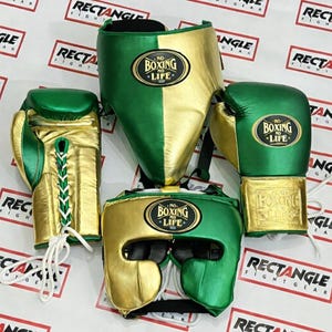 Op de afbeelding: Een boksset met groene en gouden handschoenen, hoofdbescherming en gezichtsbescherming. De handschoenen hebben witte veters en de hoofdbescherming en gezichtsbescherming tonen de tekst "NO BOXING NO LIFE". De set wordt gepresenteerd op een wit oppervlak.