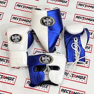 Puede incluir: Un conjunto de boxeo blanco y azul. El conjunto incluye guantes de boxeo, un protector de cabeza y una concha. Los guantes y el casco tienen el texto "NO BOXING LIFE". Los guantes son blancos con detalles azules, y el protector de cabeza es blanco y azul.
