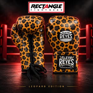 Peut inclure: Une paire de gants de boxe avec un motif léopard jaune et noir. Les gants ont des lacets noirs et des étiquettes blanches avec le texte Cleto Reyes Hecho en Mexico. Le haut de l'image affiche le texte RECTANGLE FIGHT GEAR.