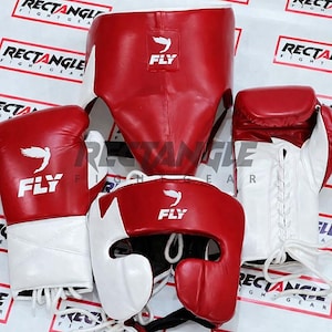 May include: A collection of red and white boxing equipment, comprising gloves, headgear, and a groin guard. Each item displays the "FLY" logo and is designed for protection during training or competition. The gear is made of a durable material.