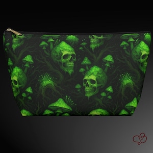 May include: A black zippered pouch with a repeating pattern of green skulls and mushrooms. The skulls have a mossy texture, and the mushrooms are dotted. The zipper is gold-colored.