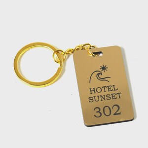 Portachiavi per camere d'albergo in plexiglass con cartellino verticale con il nome del tuo hotel e 20 numeri di camera a tua scelta (50 x 30 mm / 20 pezzi)