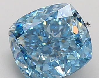 May include: A cushion-cut, light blue diamond with numerous facets. The gemstone has a square shape with rounded corners and reflects light, creating a sparkling effect. The diamond is set against a white background.