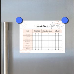 May include: A rectangular snack chart with the text "Snack Chart" and a sunburst design is attached to a stainless steel refrigerator with blue magnets. The chart has columns for days of the week and names. The refrigerator has a water and ice dispenser.
