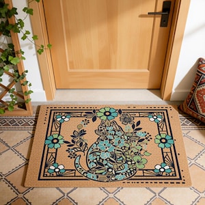 Könnte beinhalten: Eine rechteckige Fußmatte mit einem Katzendesign. Die Katze ist mit blauen und grünen Blumen und Blättern gefüllt. Die Matte hat einen schwarzen Rand mit floralen Akzenten. Der Hintergrund ist hellbraun.