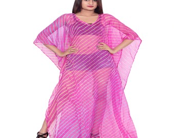 May include: A sheer, pink kaftan with a V-neck and a striped pattern. The flowing garment is made of lightweight fabric and has wide sleeves. The model is wearing black sandals.