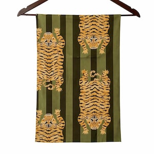 May include: A rectangular, olive green and black striped textile with four tiger illustrations. The tigers are orange and black, with their bodies oriented in different directions. The textile is hanging from a wooden hanger.