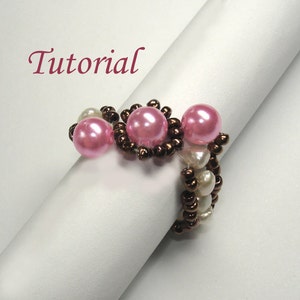 Op de afbeelding: Een roze en bruine kralenring met drie roze kralen op een witte achtergrond. Het woord "Tutorial" staat in roze boven de ring.