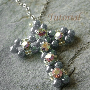 May include: A silver chain necklace with a gray beaded cross pendant featuring iridescent rhinestones. The cross is made with small gray beads and larger gray beads with rhinestones in the center. The pendant is approximately 2 inches in length.