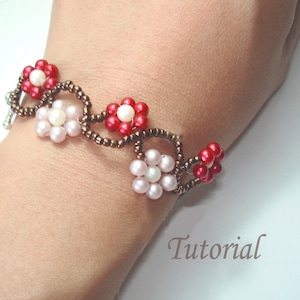 May include: A beaded bracelet with alternating red and white flower designs. The bracelet is made with brown seed beads and features a woven pattern.